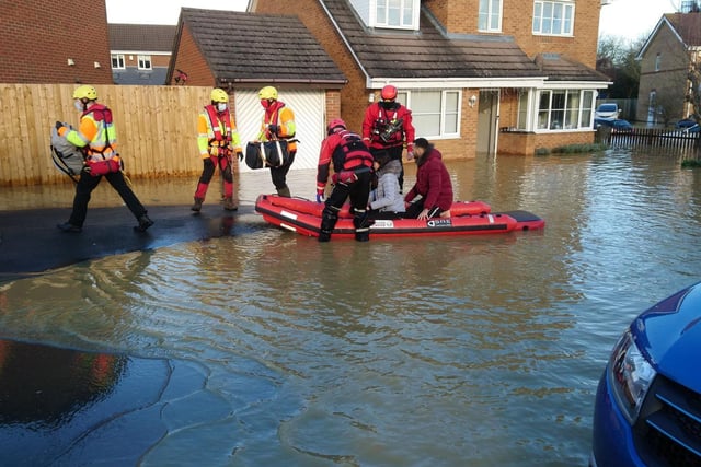 People are being taken from their homes in a rescue boat