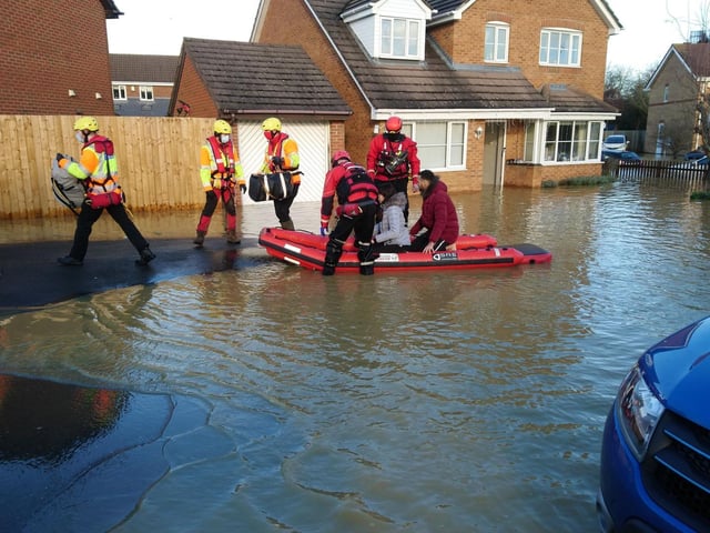 People are being taken from their homes in a rescue boat