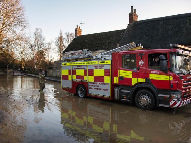 A firefighter wades through the flood water in Warkton