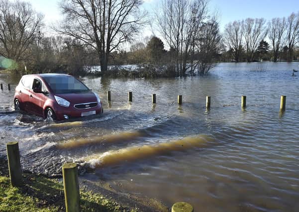 A car makes it way through flooding at Orton Mere. Picture: David Lowndes