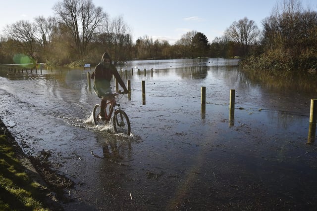 A cyclist makes his way past flood waters at Orton Mere . Picture: David Lowndes