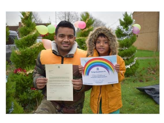 Banbury carer, Prabhu Natarajan, with his son Addhu, who hold up the 'Unsung Hero' award Prabhu received for helping the community during the ongoing Covid-19 pandemic. Banbury MP Victoria Prentis issued several 'Unsung Hero' awards this year.