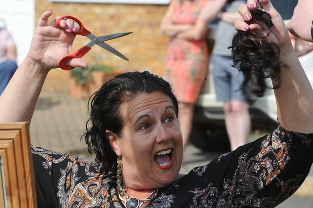Sally Dowers from Whittlesey doing her own head shave to raise funds for Sue Ryder following the death of her father, well known local cricketer, Alan Weston - in her front garden watched by residents of the cul-de-sac in April.