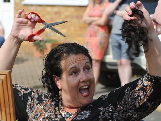 Sally Dowers from Whittlesey doing her own head shave to raise funds for Sue Ryder following the death of her father, well known local cricketer, Alan Weston - in her front garden watched by residents of the cul-de-sac in April.