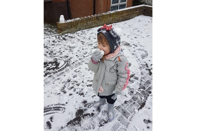 Emily, aged 4, eats a snow apple near her Banbury home (photo from Nicole Ainsworth)