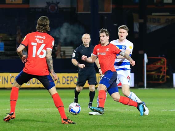 James Collins lays the ball back to Glen Rea during Luton's 2-0 defeat to QPR