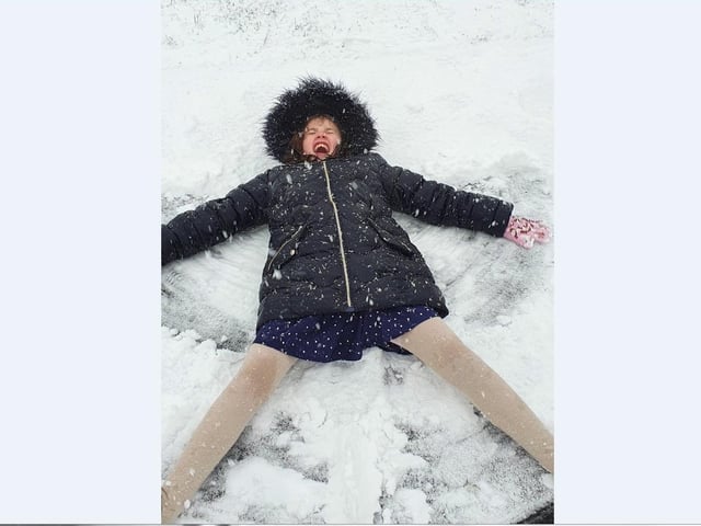 Kevin Gibbs' children enjoy making snow angels in Newborough