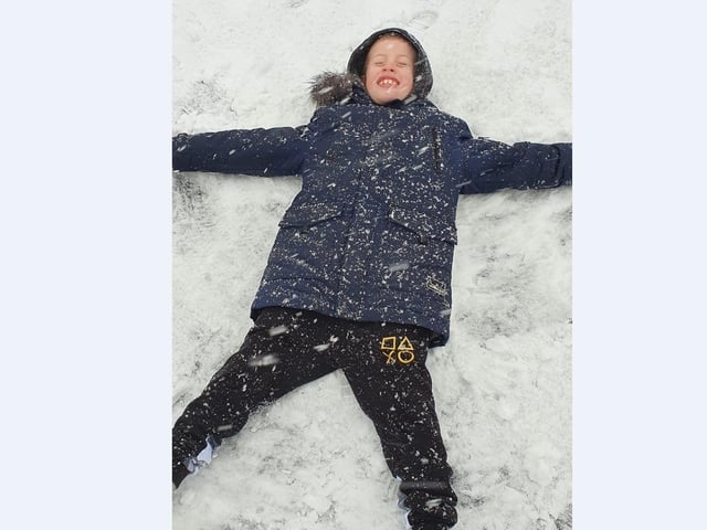 Kevin Gibbs' children enjoy making snow angels in Newborough