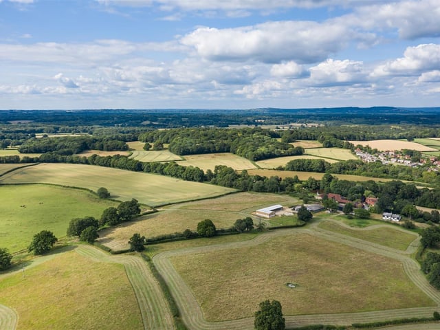 A rural 20-acre building plot with fields and paddock in a slightly elevated position with planning consent for a detached house, cottage and equestrian/agricultural complex. Price: £900,000.