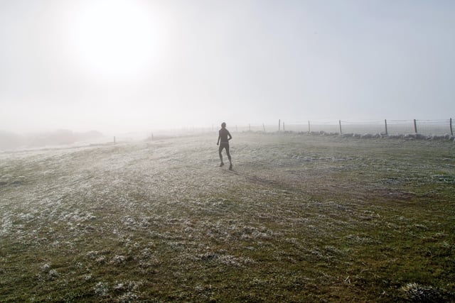 A runner on the Downs above Eastbourne vanishes into the winter fog, Taken by Barry Davis with a Canon 5d Mark iii. SUS-210127-144700001