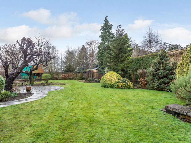 The gardens have a high stonewall along the western boundary and are designed with a central lawn, pretty borders and a wide variety of flowers, evergreen beds, mature fruit trees, conifers and a Foxglove tree. There is also an entertaining patio and large garden machinery storage shed.
