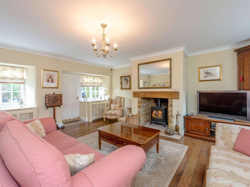 The drawing room has a central fireplace encasing a wood-burning stove together with a door opening onto the entertaining terrace