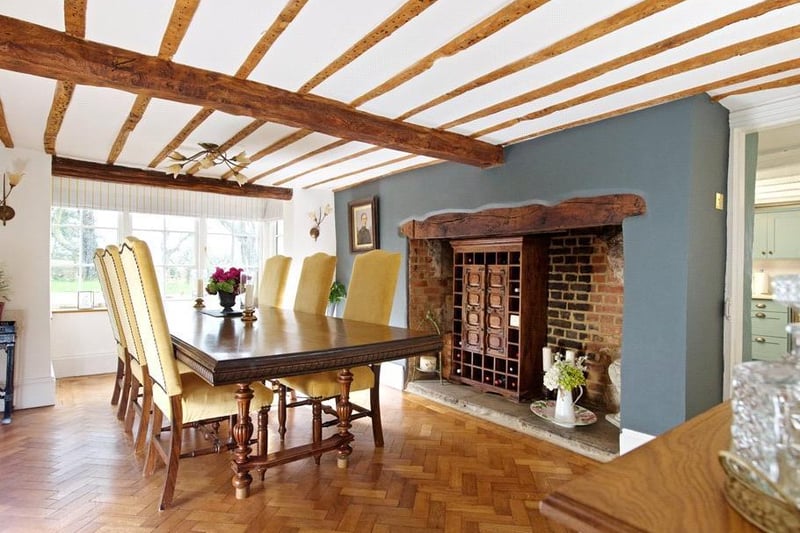 The dining room has Oak parquet flooring, exposed ceiling beams, a box bay window to the front and an inglenook fireplace.