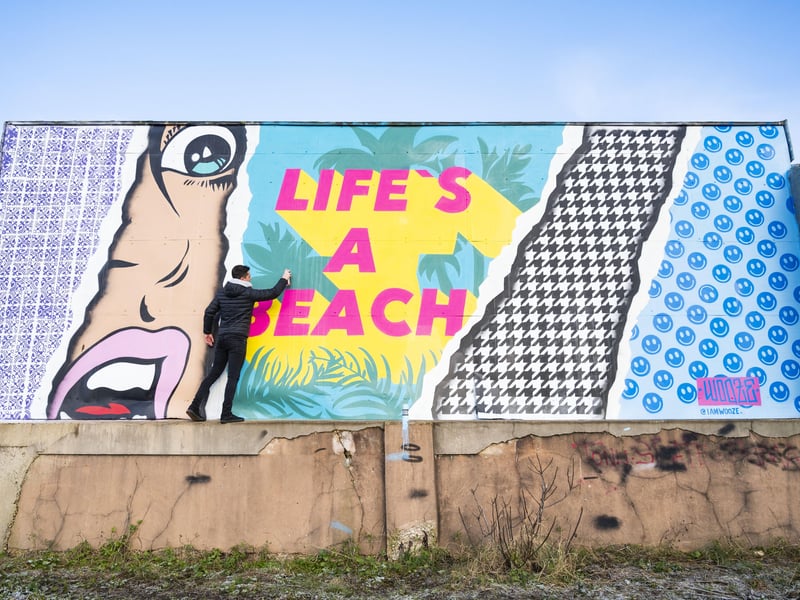 Luke Henley with his mural in front of the Perch in Lancing. Picture: Luke Henley