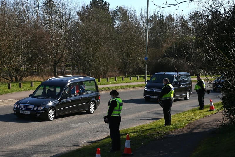 Police officers bow their heads as the funeral procession for Sir Tom Moore passes through Bedford (Photo by Hollie Adams/Getty Images)