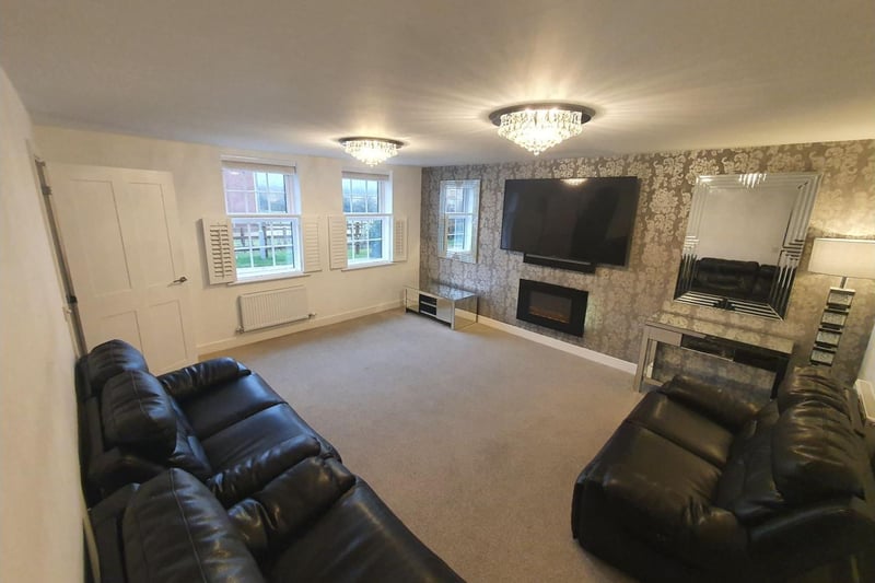 This spacious comfortable living room comfortably fits three sofas and could easily expand for social events or the largest of families.