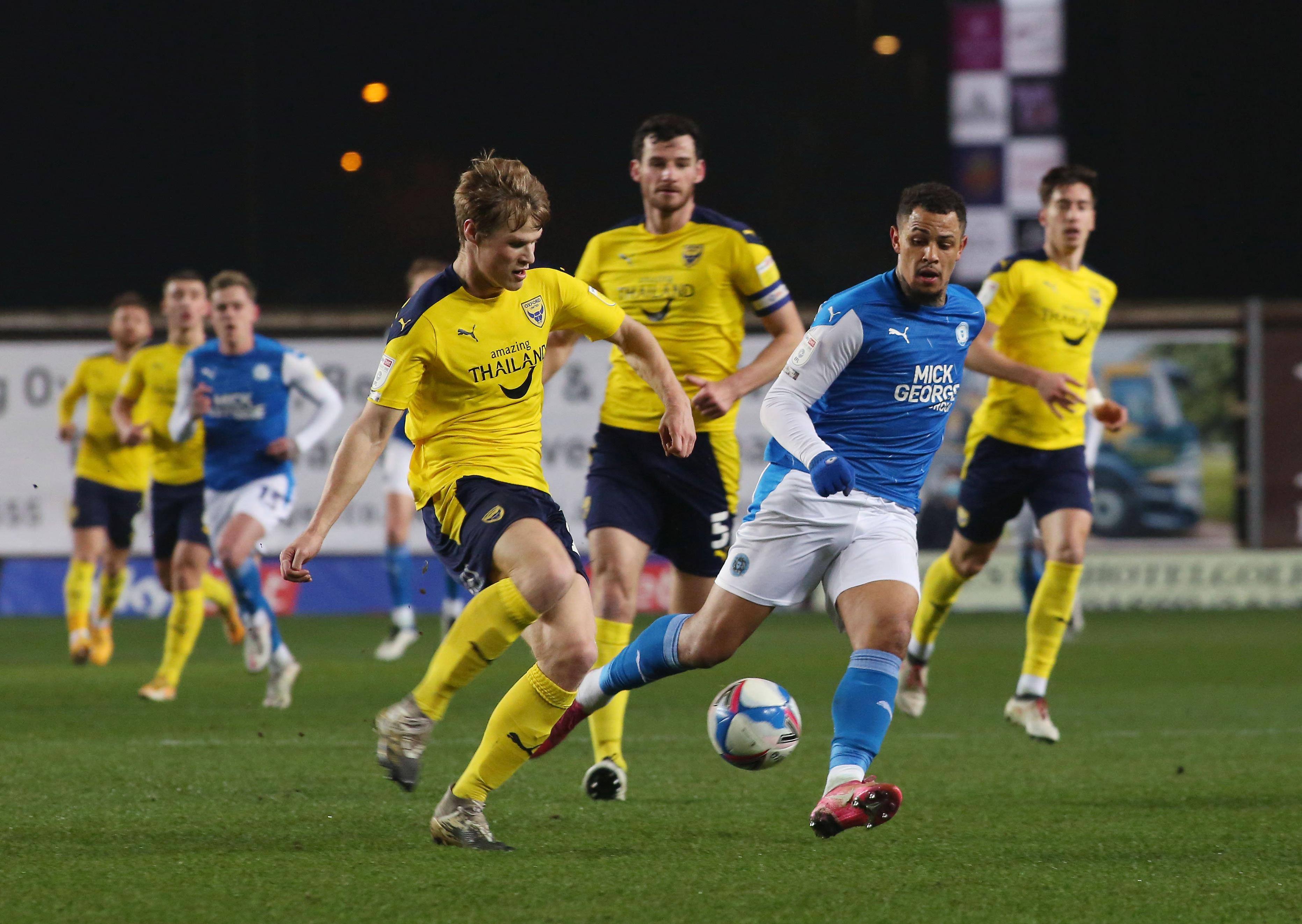 Jonson Clarke-Harris of Peterborough United in action with Rob Atkinson of Oxford United. Photo: Joe Dent/theposh.com
