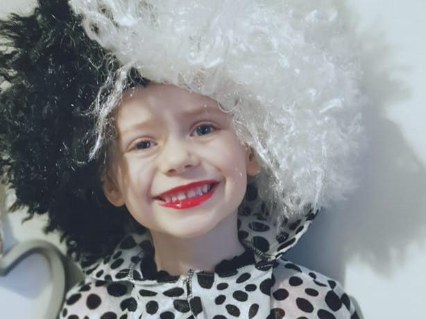 Kionie, aged 4, has spent all morning transforming into Cruella Deville with trademark red lipstick and black and white curly hair.
