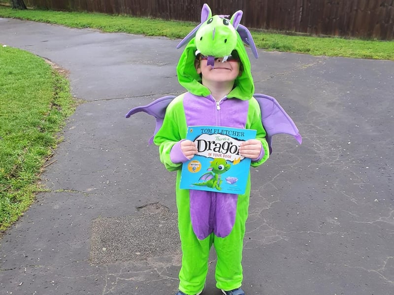 Smiley Finley Cullum has dressed up as the dragon from 'There's A Dragon In My Book'.