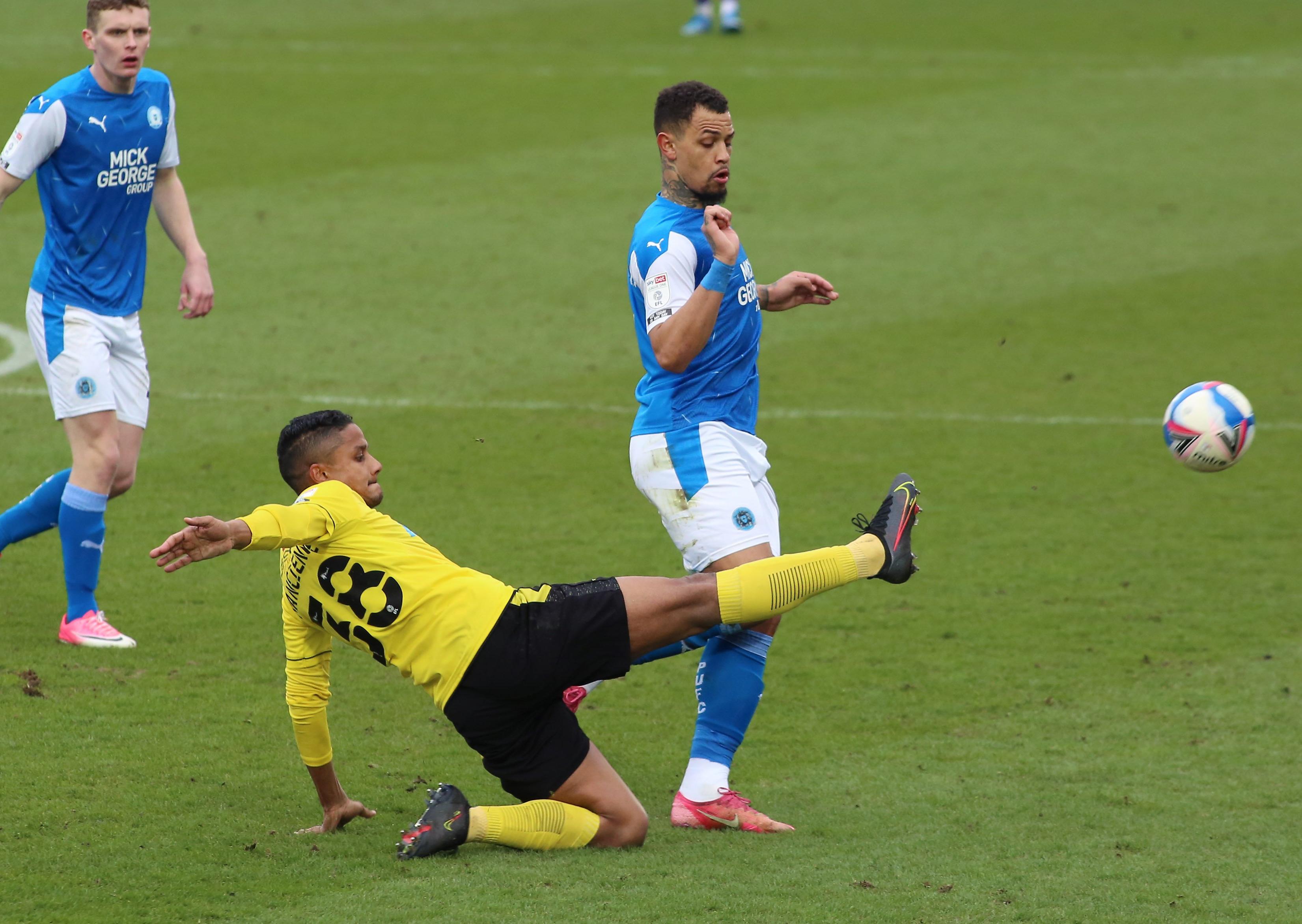 Jonson Clarke-Harris of Peterborough United challenges for the ball with Michael Mancienne of Burton Albion. Photo: Joe Dent/theposh.com.
