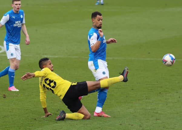 Jonson Clarke-Harris of Peterborough United challenges for the ball with Michael Mancienne of Burton Albion. Photo: Joe Dent/theposh.com.
