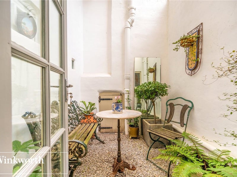 Through a short hallway there is a cloakroom and an enclosed quaint courtyard where one can relax, engage and hideaway on a hot summer's day.