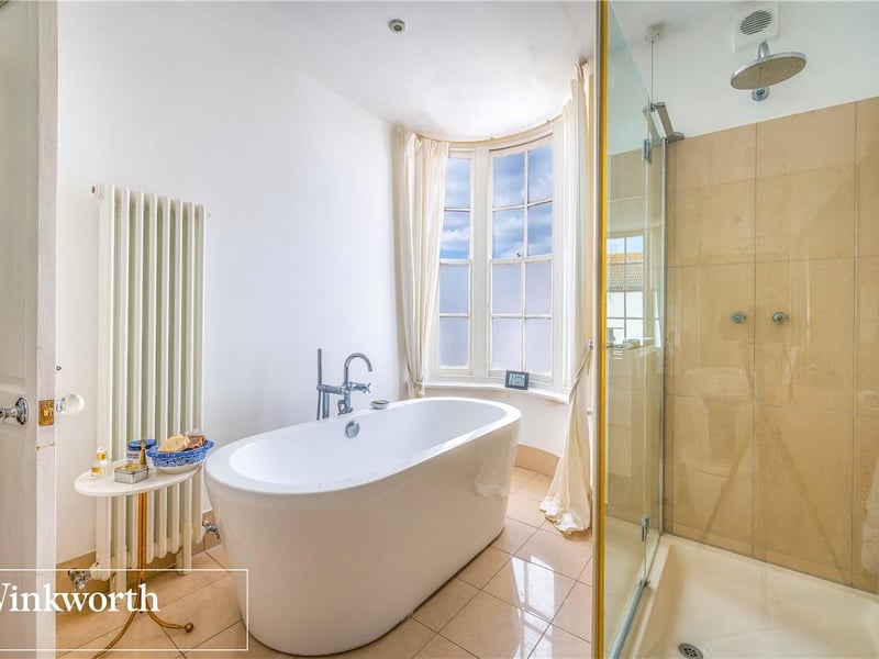 Spacious bathroom featuring a roll top bath and a double shower unit.