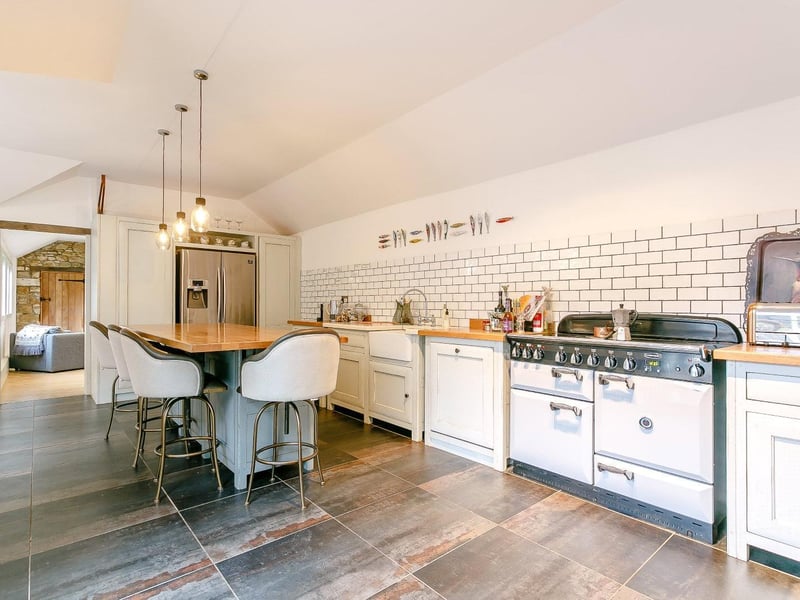 Free-standing Fired Earth kitchen with central island, electric range cooker, American-style fridge/freezer, integrated dishwasher and walk-in larder/pantry.