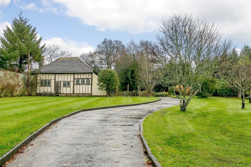 An imposing driveway which, along with the two-bay car barn, provides ample parking.