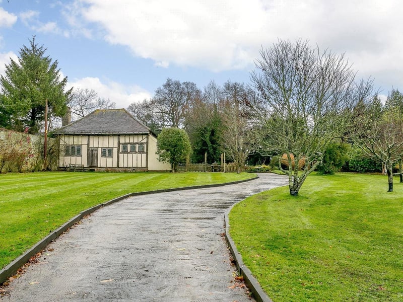 An imposing driveway which, along with the two-bay car barn, provides ample parking.