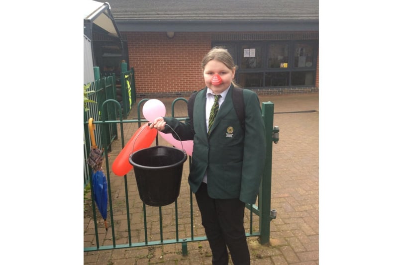 Isobel White, a year six student, stands on the gate at Dashwood Academy collecting money for Red Nose Day to benefit Comic Relief (photo from Dashwood Academy)