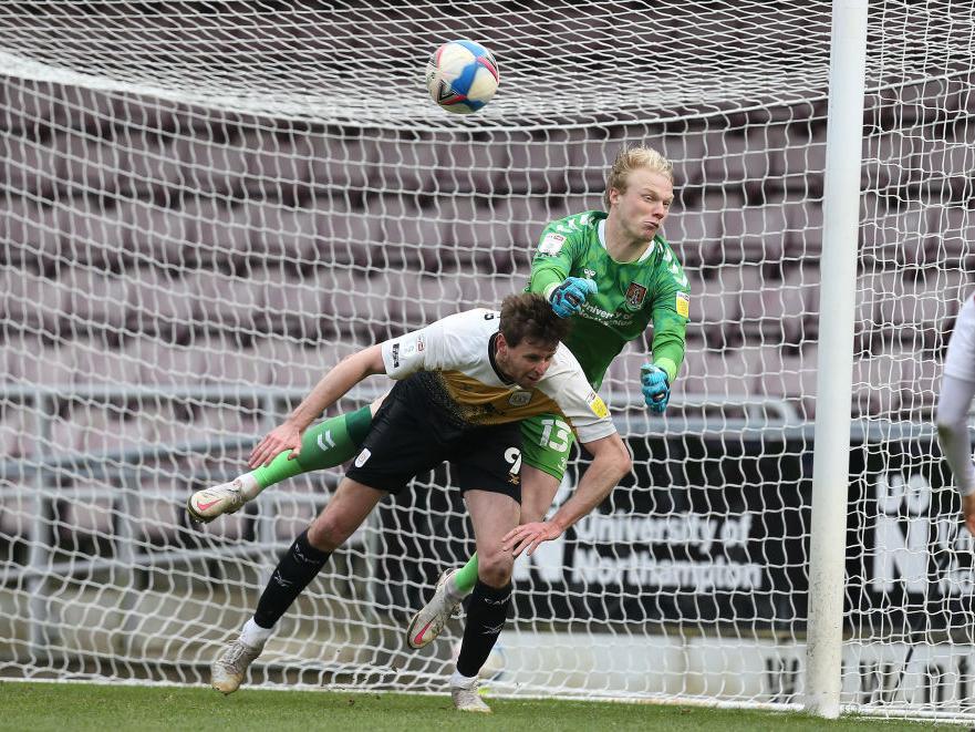 Jonathan Mitchell punches a free-kick away under pressure from Chris Porter. Pictures: Pete Norton.