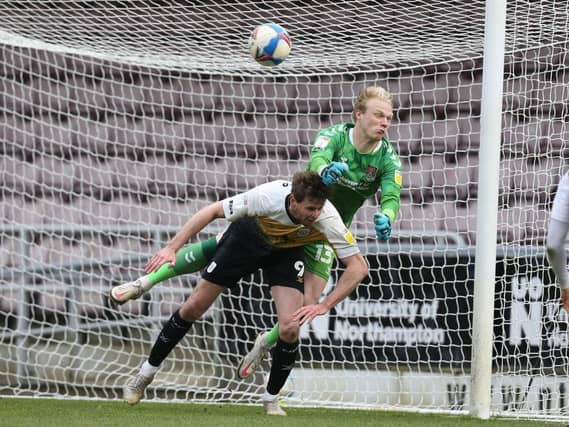 Jonathan Mitchell punches a free-kick away under pressure from Chris Porter. Pictures: Pete Norton.