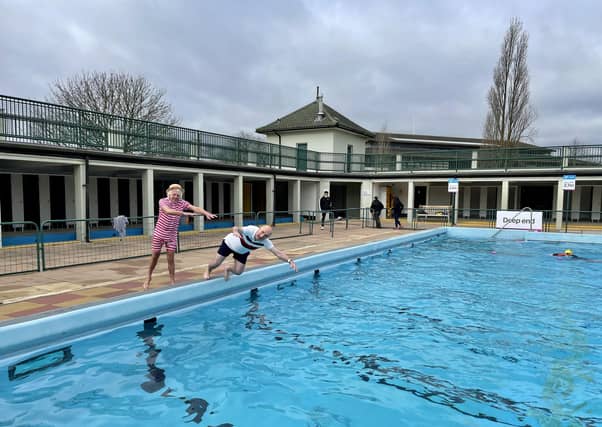 Bill Marriott pushes John Peach into the pool to mark the opening of the 2021 swimming season.