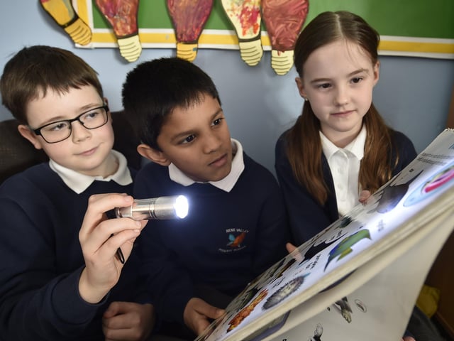 Year 3/4 children at Nene Valley Primary School reading with a torch because all lights were turned off for Climate Action Day EMN-200403-170328009