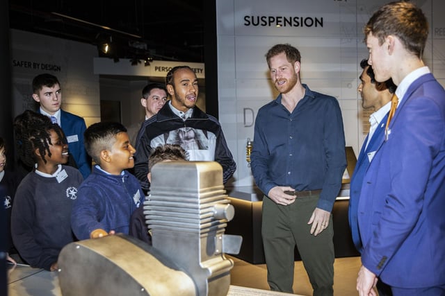 Schoolchildren explain the various displays at The Silverstone Experience to Prince Harry and Lewis Hamilton