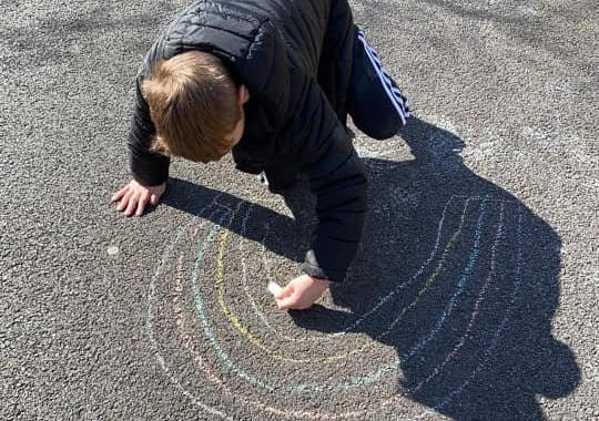 Riley, aged 9, makes a chalk rainbow