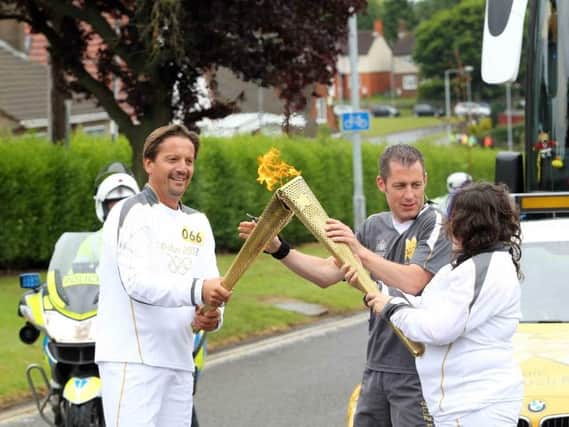 Torchbearer Paolo Dante hands the torch over to Hannah Sanchez.