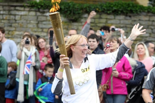 Torchbearer Barbara Crowther from Desborough waves to the crowd