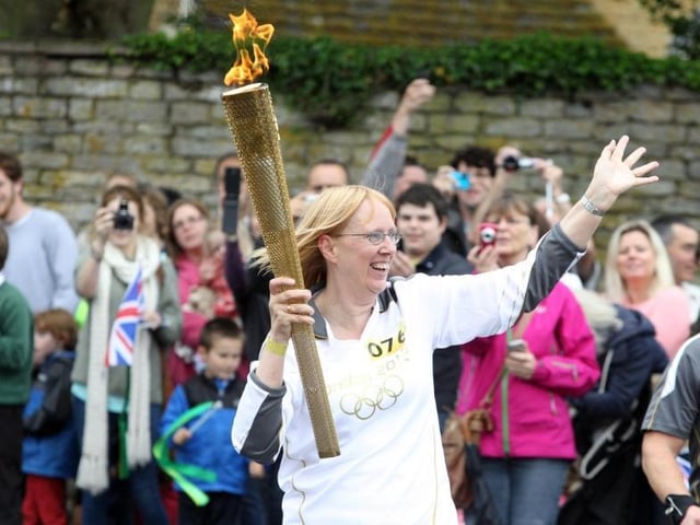 Torchbearer Barbara Crowther from Desborough waves to the crowd