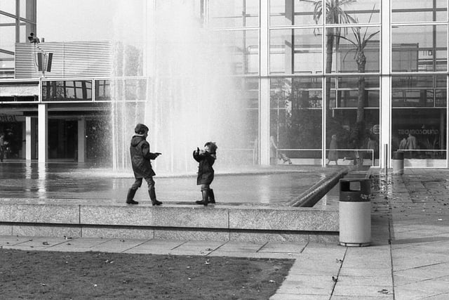 Two children enjoying the fountains