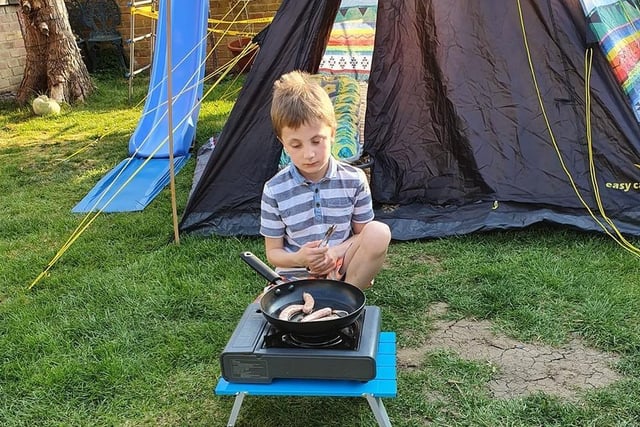 A scout cooks sausages during the Oxfordshire Scouts virtual camp weekend