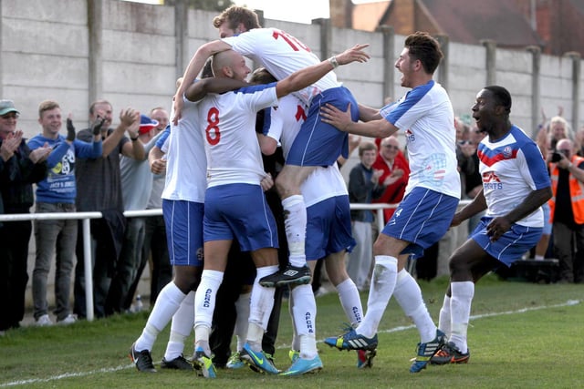 Alfie Taylor is mobbed by his team-mates after the late winner