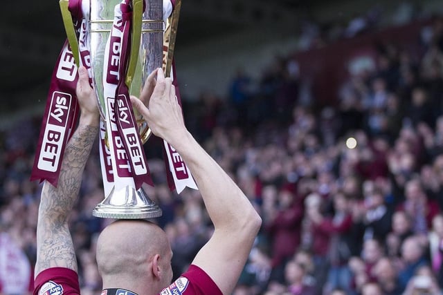 Ryan Cresswell shows off the league two trophy to the west stand faithful