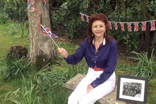 Cllr Sharon Davy, Lewes District Council’s elected Armed Forces Champion, is pictured in her garden remembering VE Day, with a photo of her late father and some of the crew of HMS Campbell. SUS-201105-132740001