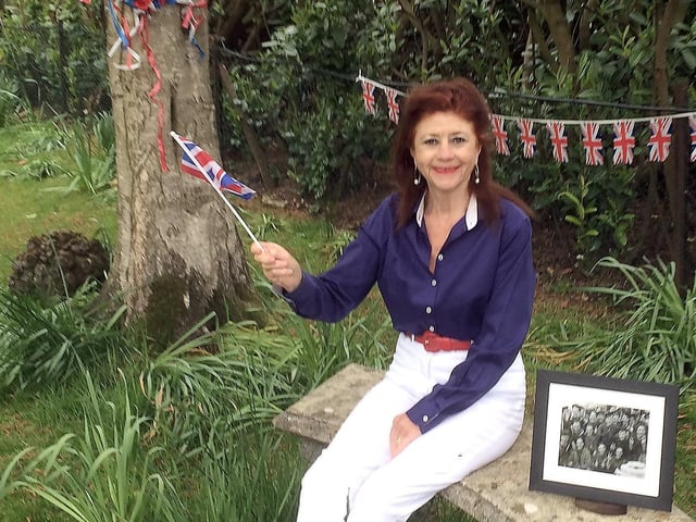 Cllr Sharon Davy, Lewes District Council’s elected Armed Forces Champion, is pictured in her garden remembering VE Day, with a photo of her late father and some of the crew of HMS Campbell. SUS-201105-132740001