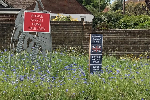 Joan Foster, chairman of Hunston Parish Council, sent in this picture of the VE Day notice on the roundabout, along with the wildflowers sown by Hunston Brownies in November