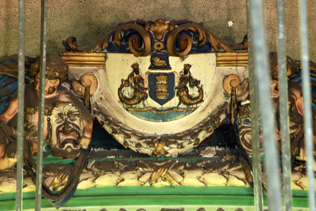 The Boston coat of arms above the stage, and what appears to be the sock and buskin comedy and tragedy masks either side of it.