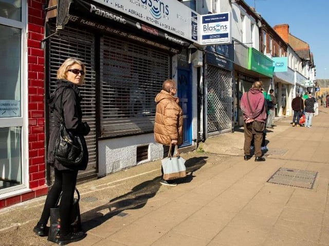Patience is a virtue in the new social distancing era as the queue stretches along Wellingborough Road, Northampton, for Lloyds Pharmacy