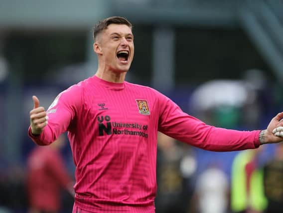Goalkeeper Liam Roberts, who kept another clean sheet, lets out a roar of delight in front of Cobblers' jubilant away fans at Prenton Park on Saturday. Pictures: Pete Norton.